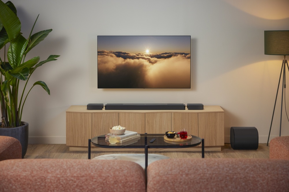 Soundbar JBL BAR 1300 MK2 v obývacím pokoji umístěný pod televizí na televizním stolku