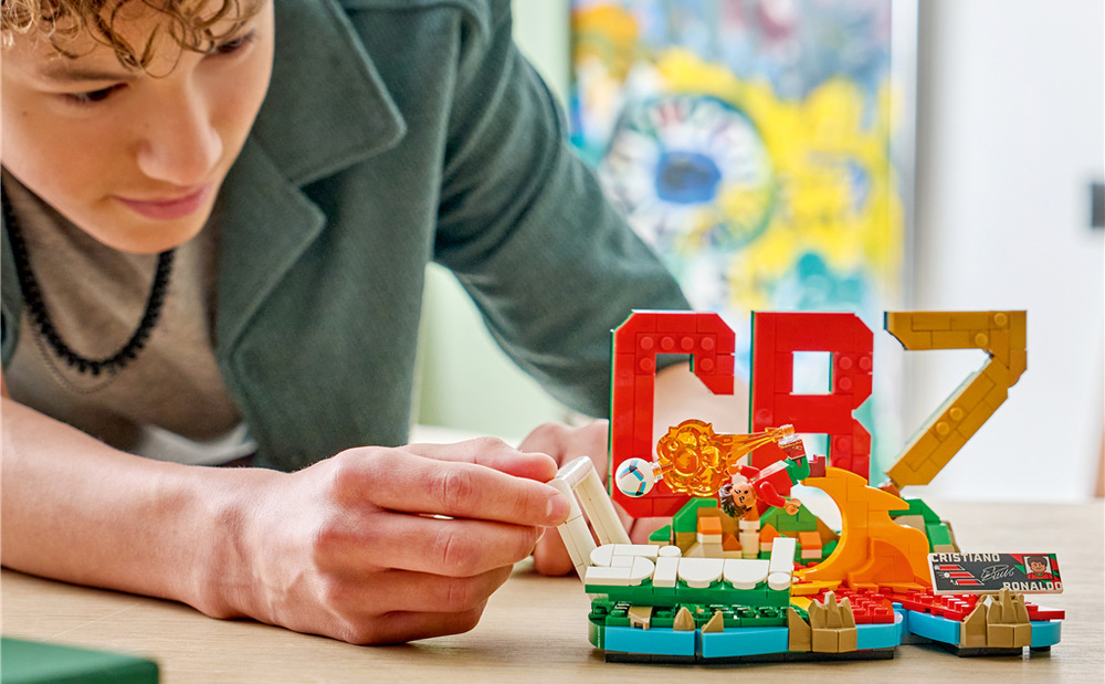 Stavebnice LEGO® Editions 43012 Cristiano Ronaldo – Hvězdné momenty fotbalu Podstavec zdobí iniciály, portugalské barvy, označení CR7 a plaketa s podpisem a statistikami hráče