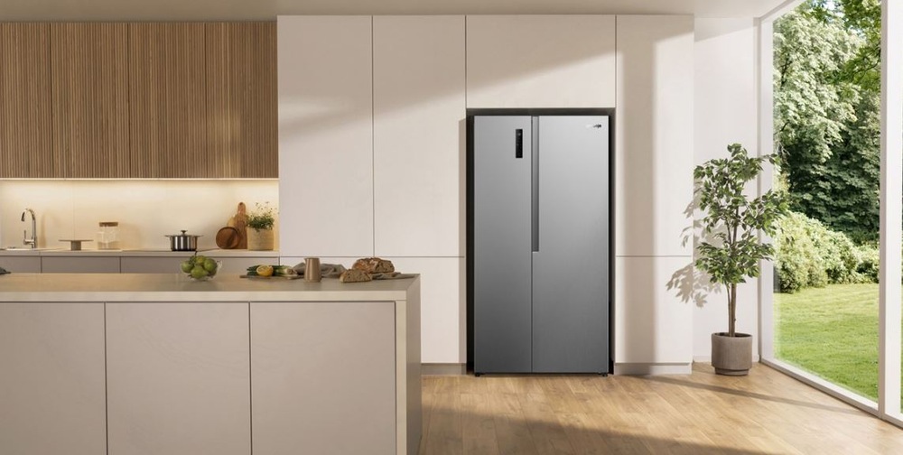 Americká lednice Gorenje G400 NRS917E41X nerez nerezová lednice Gorenje NRS917E41X ve světle kuchyni v dřevěnem dekoru. Stoji u prosklene stěny na terasu.