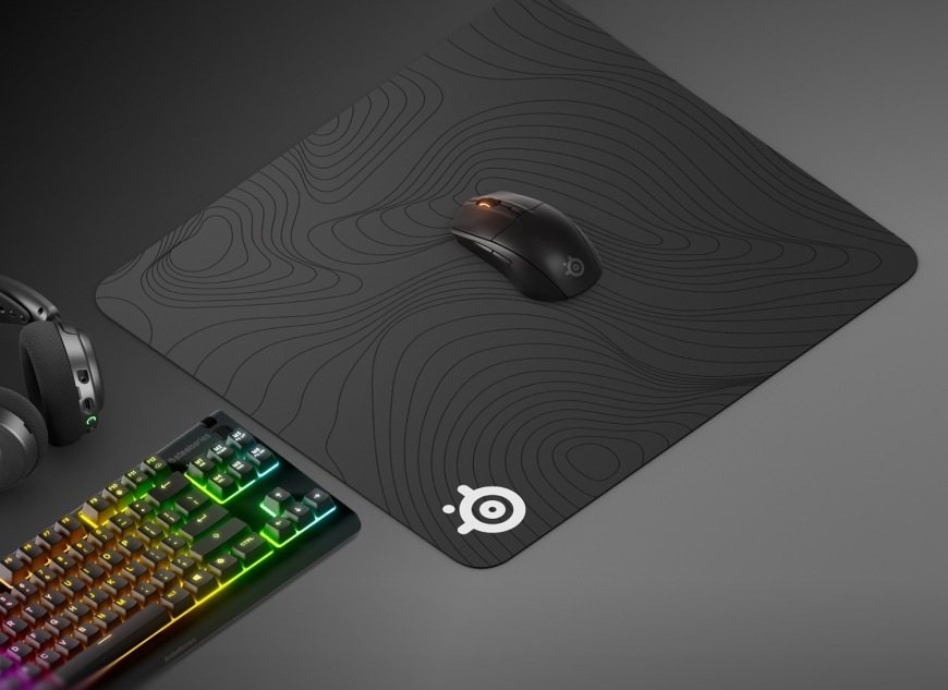 Podložka pod myš SteelSeries QcK Large, Topographic černá Myš na podložce QcK Large Topographic vedle headsetu a klávesnice s RGB podsvícením