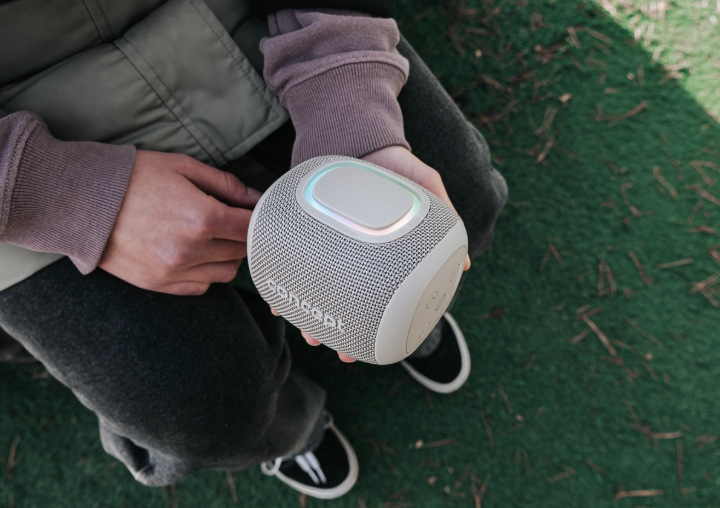 Uživatel drží v ruce reproduktor Concept SoundJoy BR5011 s rozsvíceným LED prvkem