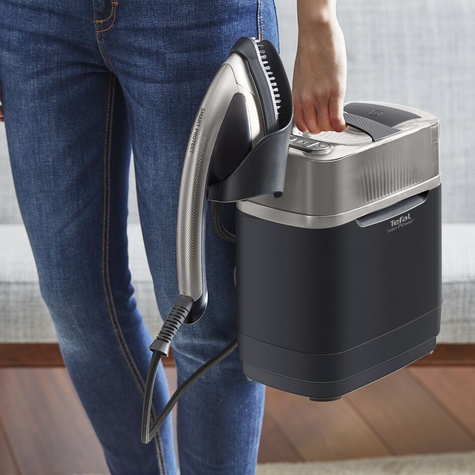 Muž přenáší napařovač Tefal QT2028F0 Ixeo Power