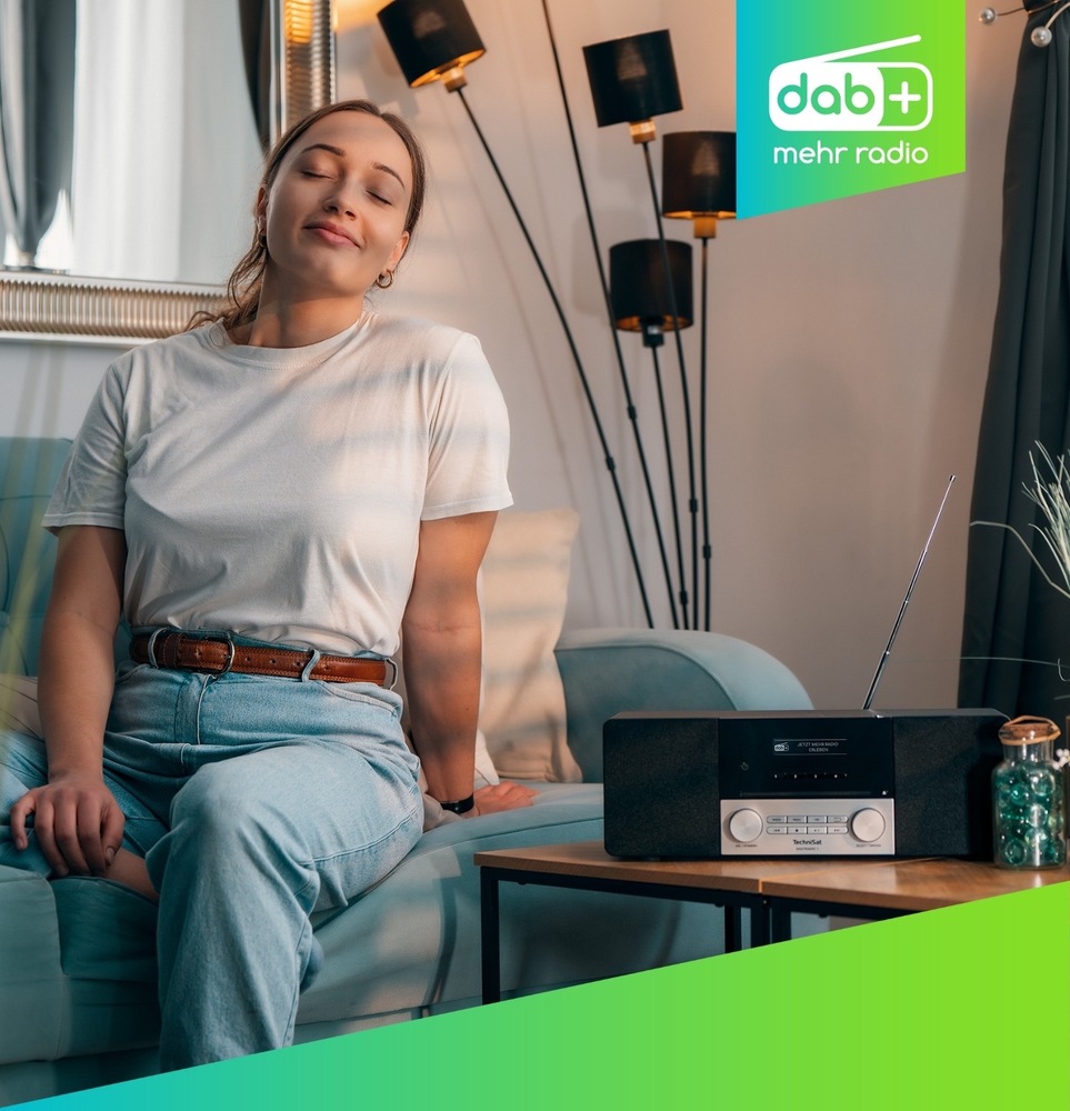 Radiopřijímač DAB+/CD TechniSat DIGITRADIO 3 ASA černý/stříbrný Mladá žena se zavřenýma očima poslouchá rádio TechniSat umístěné na stolku vedle pohovky. Přístroj má vysunutou anténu a zapnutý displej. Grafika vpravo nahoře označuje příjem DAB+.