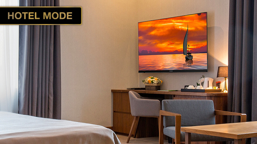 Televize Hyundai HL 327602V Hotelový režim Hotel Mode na televizoru: Televizor zavěšený na stěně v elegantním hotelovém pokoji. Štítek: HOTEL MODE.