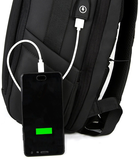 Mobilní telefon připojený k USB kabelu na batohu.