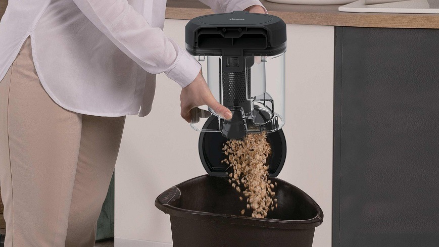 Podlahový vysavač Hoover HP210P 011 černý/šedý osoba sype nečistoty z nádoby na prach do koše
