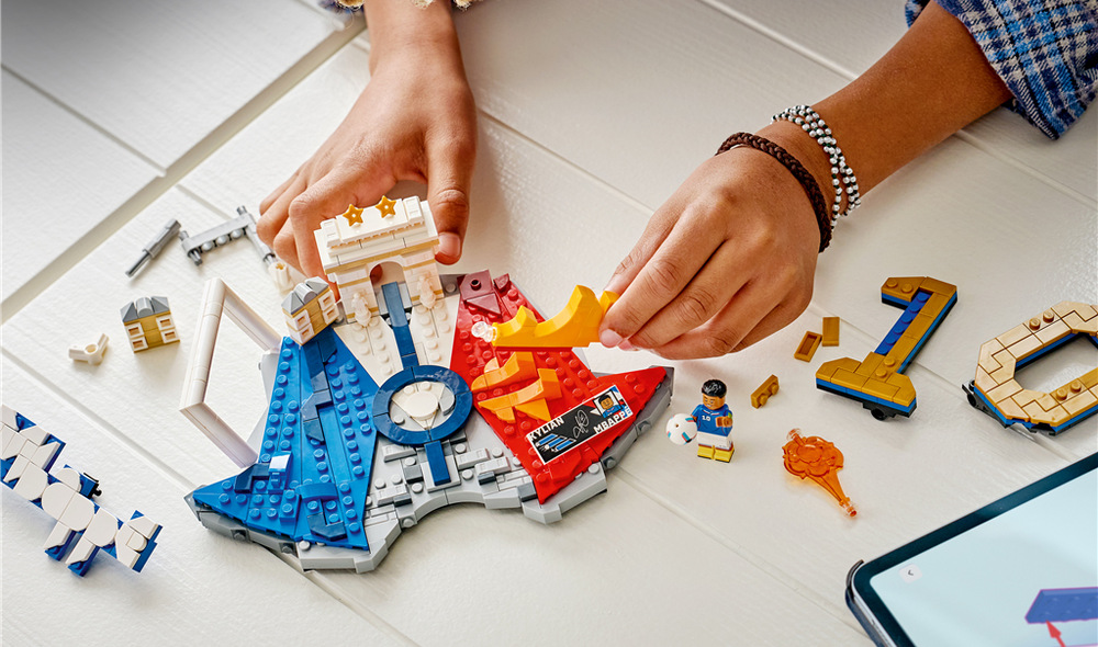Stavebnice LEGO® Editions 43013 Kylian Mbappé – Hvězdné momenty fotbalu Minifigurku Kyliana Mbappého doplňuje základna s iniciálami, francouzskými barvami, číslem 10 a sběratelskou plaketou