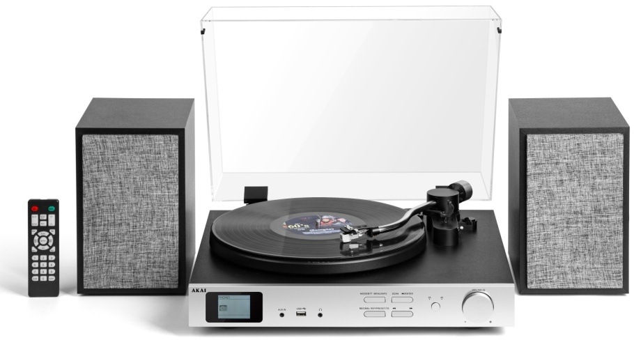 Gramofon AKAI ATT-500SP černý/stříbrný Gramofonová sestava Akai zepředu s puštěnou deskou a dálkovým ovladačem u reproduktoru.