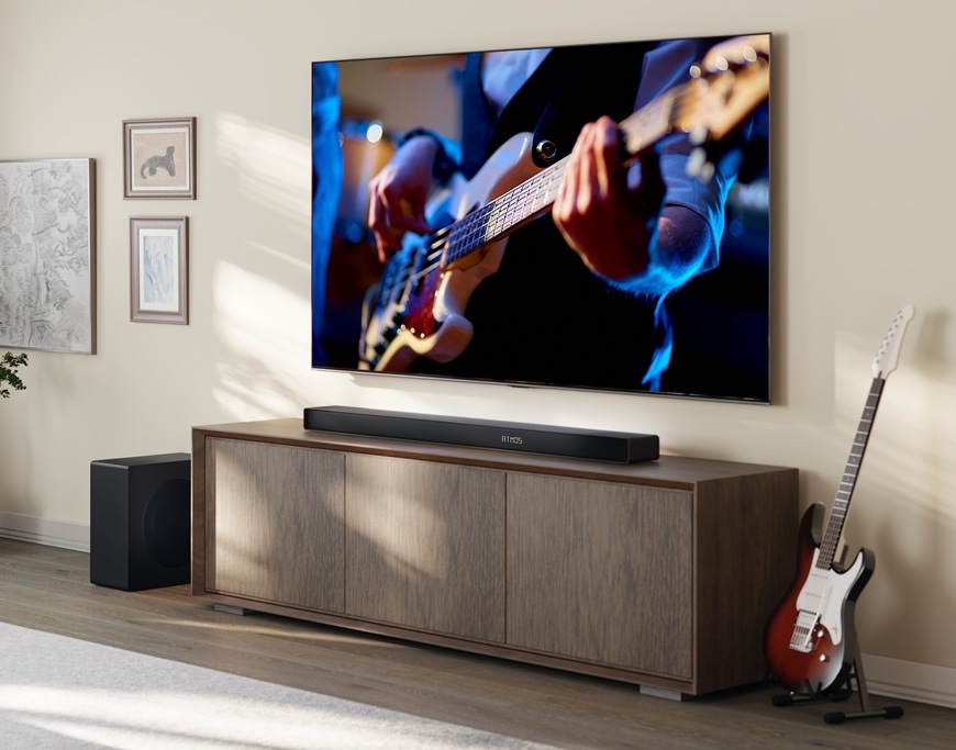 Soundbar Hisense AX3120Q černý Soundbar Hisense AX3120Q je umístěn v moderní domácnosti pod televizorem Hisense. V televizi hraje muž na kytaru.