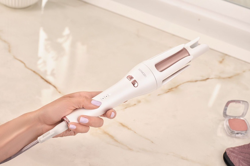 Kulma loknovací Sencor SHS 0925RS bílá/bronzová Žena drží v ruce kulmu Sencor SHS 0925RS