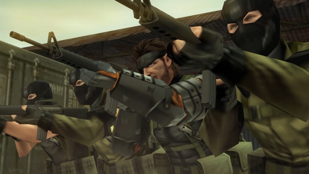 Scéna ze hry Metal Gear Solid: Peace Walker. Tři ozbrojení vojáci v taktickém vybavení a maskách mířícími puškami, zasazení do napjatého, prašného prostředí. Postava uprostřed je bez masky a má soustředěný výraz.