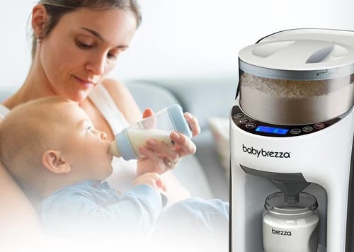 Ohřívač mléka Baby Brezza Formula Pro Advanced Classic bílý Detail na fotku, na jedné straně je dávkovač mléka Baby Brezza Formula Pro Advanced Classic a na druhé straně je maminka, která v náručí lahvičkou krmí miminko.