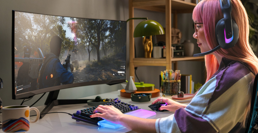 Klávesnice Logitech G512 X 75, US INTL layout, Tactile bílá Hráčka používající Logitech G512 X 75 při hraní akční hry na širokoúhlém monitoru