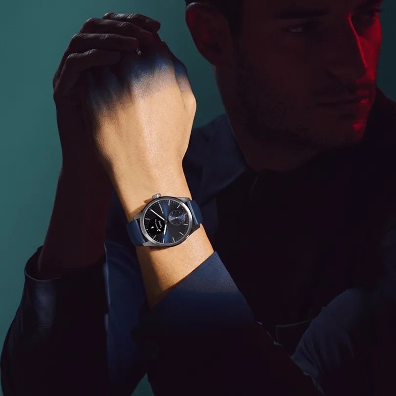 Muž se sepnutýma rukama má na zápěstí chytré hodinky Withings ScanWatch 2