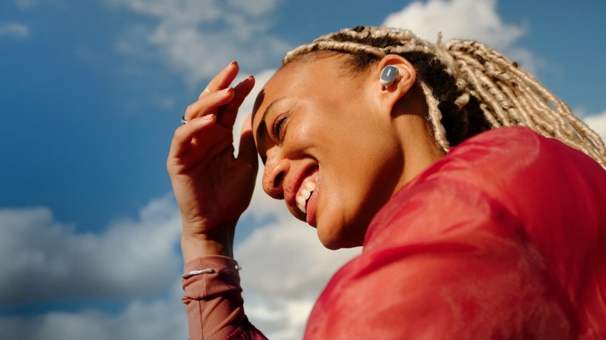 Sluchátka Bose QuietComfort Ultra Earbuds ( 2Gen ) černá/zlatá Usmívající se žena se sluchátky Bose QuietComfort Ultra Earbuds (2nd Gen)