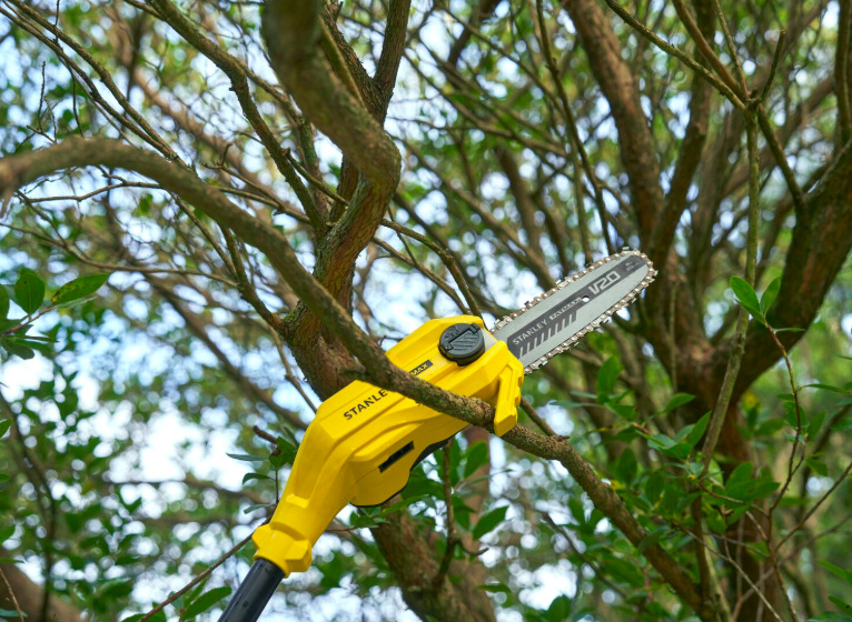 Odvětvovač Stanley FatMax SFMCPS720B-XJ (bez baterie) Detail lišty odvětvovače Stanley FatMax SFMCPS720B-XJ při řezání větve stromu