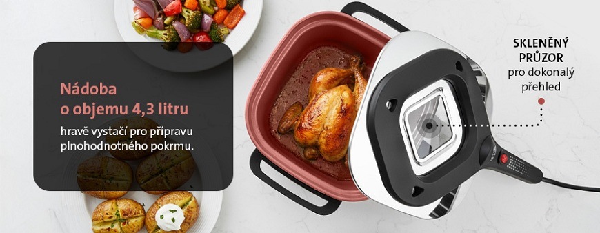 Pohled shora na červenou nádobu pečicího hrnce ETA Pečenka o objemu 4,3 litru, s víkem se skleněným průzorem a upečeným kuřetem uvnitř