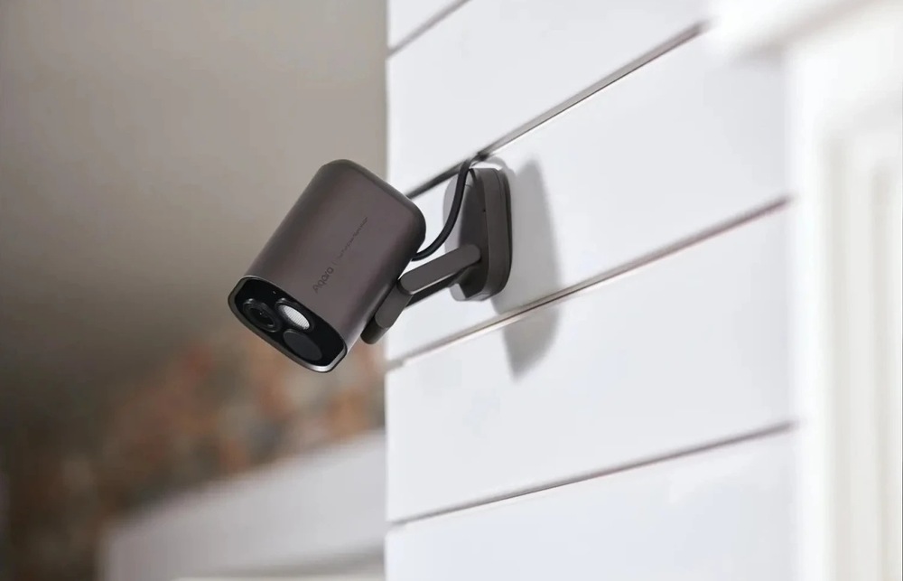 Kamera Aqara G5 Pro PoE namontovaná na venkovní stěně domu.