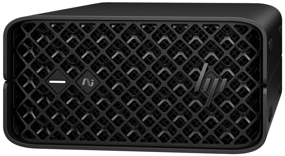 PC mini HP Z2 Mini G1a černý Na obrázku je kompaktní stolní počítač HP Z2 Mini G1a v černém provedení, zachycený zepředu a mírně zboku. Má nízké obdélníkové tělo se zaoblenými rohy a celou čelní stranu kryje výrazná mřížka s hustým kosočtvercovým vzorem. Vlevo na čele jsou dva malé ovládací prvky a vpravo je logo HP.