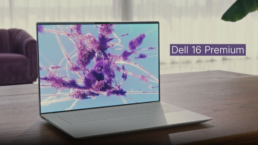 Místnost s křeslem a stolem, na kterém je notebook Dell 16 Premium DA16250, stříbrná barva