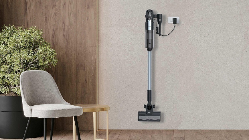 Tyčový vysavač Hoover HF310H 011 visí na nástěnném držáku a nabíjí se