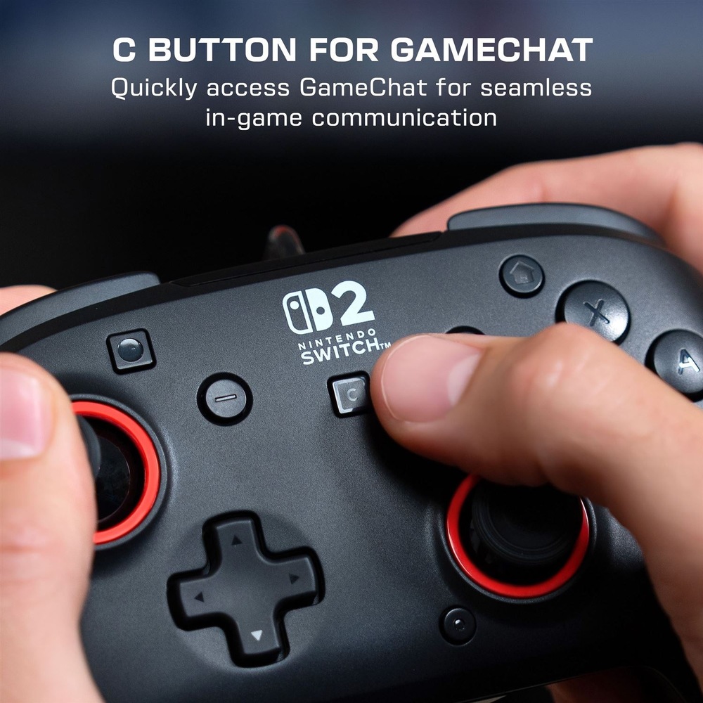 Na obrázku je detail černého gamepadu Turtle Beach Rematch Wired drženého v rukou. Uprostřed je bílé logo Nintendo Switch 2 a prst právě mačká tlačítko C pro rychlé otevření funkce GameChat. Vidět jsou také analogové páčky s červenými kroužky, směrový kříž a hlavní ovládací tlačítka. Horní text upozorňuje na snadný přístup k herní komunikaci.