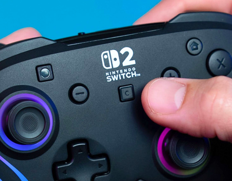 Hráč stiskuje tlačítko C pro otevření funkcí GameChat na Nintendo Switch 2