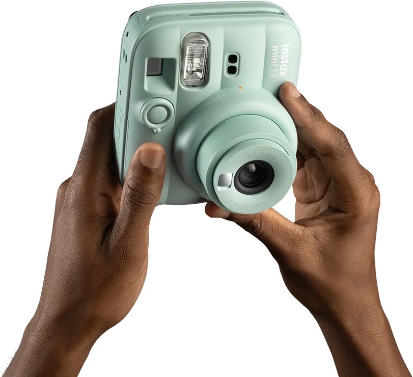 Instantní fotoaparát Fujifilm instax mini 13 fialový Detail rukou ovládajících instax mini 13 pomocí otočného objektivu