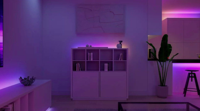 LED pásek osvětlující obývací pokoj nepřímým fialovým a modrým světlem