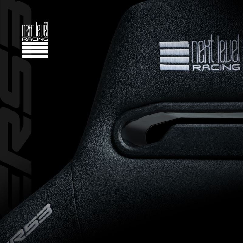 Detail černého závodního sedadla s texturovaným čalouněním, bočním otvorem pro bezpečnostní pásy a stříbrným logem „next level racing“; tmavá, elegantní estetika motoristického sportu.