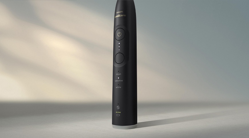 Elektrický zubní kartáček Philips Sonicare 6500 HX7411/10 v černém provedení, detail rukojeti s tlačítky, indikací režimů a stavem baterie.