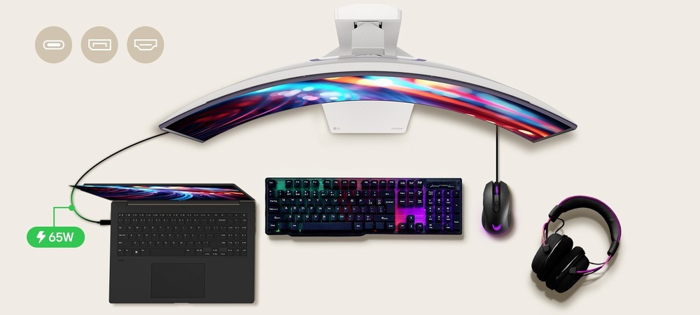 Herní monitor LG UltraGear 34GX90SA-W černý/bílý Zakřivený monitor zobrazující zářivé abstraktní barvy, připojený k černému notebooku, RGB klávesnici, myši a sluchátkům. Zobrazuje se ikona nabíjení 65 W.