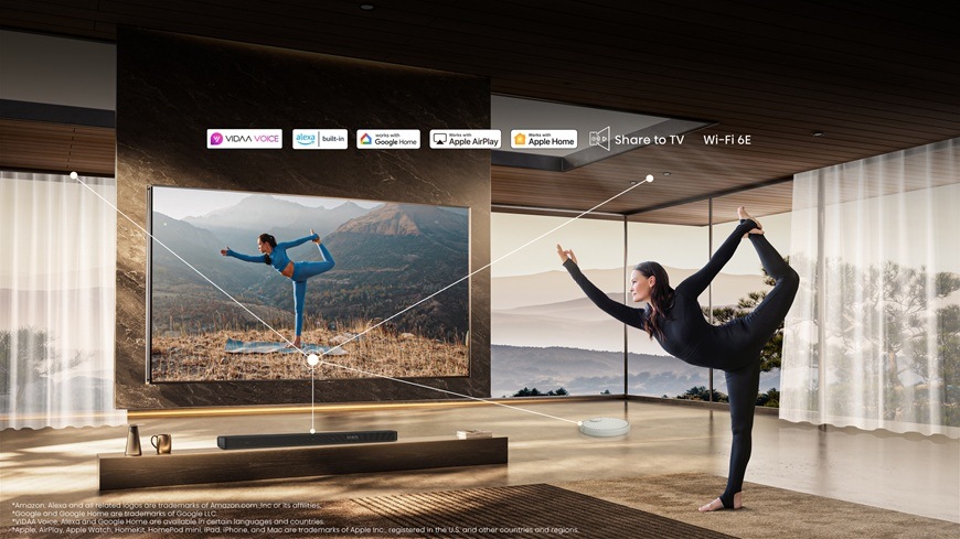Televize Hisense 116UXQ Na obrázku je žena, cvičící před televizorem Hisense 116UXQ a dává televizi s kompatibilitou chytré domácnosti hlasové příkazy v českém jazyce.