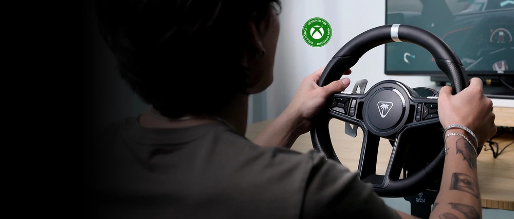Volant Turtle Beach VelocityOne Race KD3 Direct Drive - PC, Xbox One/Series černý Záběr na uživatele držícího v rukou volant Turtle Beach VelocityOne Race KD3. Na pozadí vidíme monitor zobrazující scénu ze závodní hry.