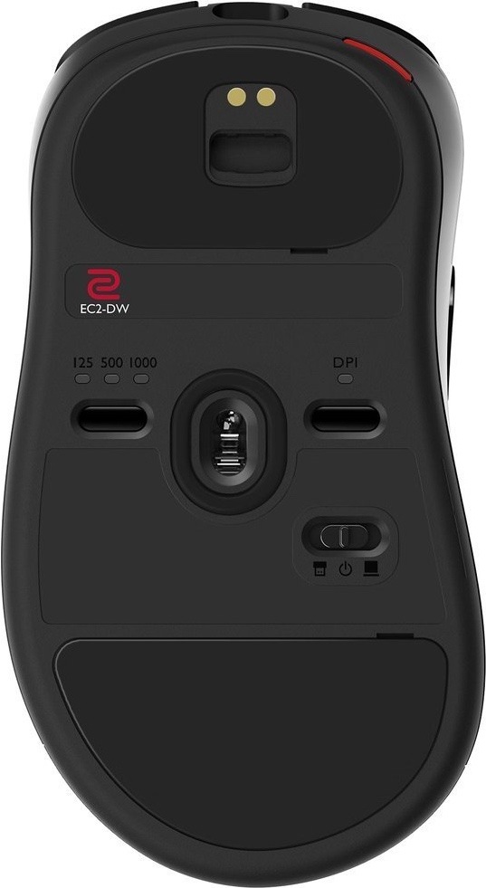 Spodní strana bezdrátové myši ZOWIE by BenQ EC2-DW ukazuje optický senzor uprostřed, velké kluzné plošky a ovládací prvky pro nastavení. Vlevo je přepínač frekvence 125, 500 nebo 1000 Hz, vpravo tlačítko DPI pro změnu citlivosti. Dole je posuvný přepínač režimu připojení a nahoře jsou kovové kontakty pro nabíjení v dokovací stanici.