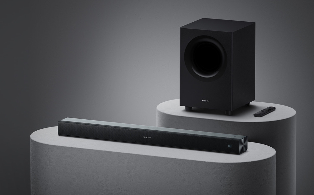 Soundbar Xiaomi PRO 2.1 ch s bezdrátovým subwooferem umístěný v moderním pokoji pro domácí kino