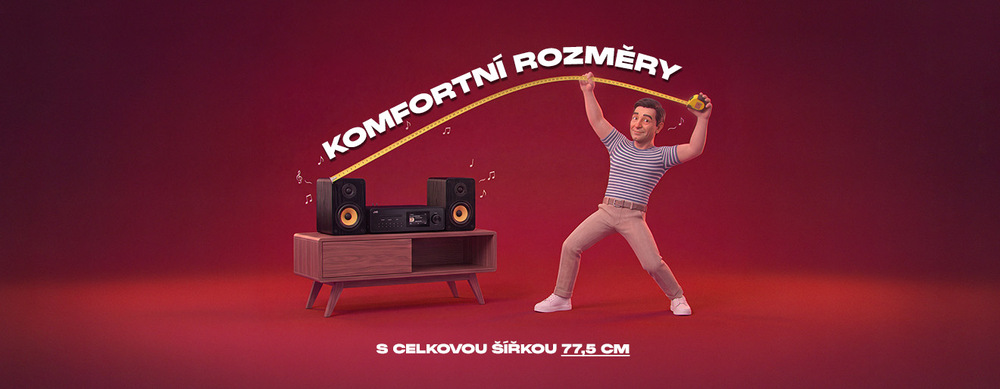 Muž měří svinovacím metrem mikrosystém JVC MX-E455 na stolku. Banner s textem „Komfortní rozměry s celkovou šířkou 77,5 cm“.