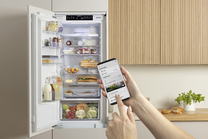 Chladnička Gorenje G400 RI517E41WF bílá Žena má v mobilu otevřenou aplikaci ConnectLife, přes kterou ovládá lednici Goenje