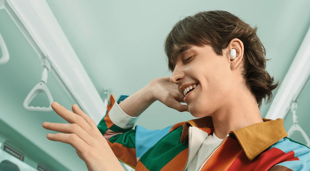 Sluchátka Xiaomi Redmi Buds 6 Play černá Muž poslouchá hudbu skrz sluchátka Xiaomi Redmi Buds 6 Play