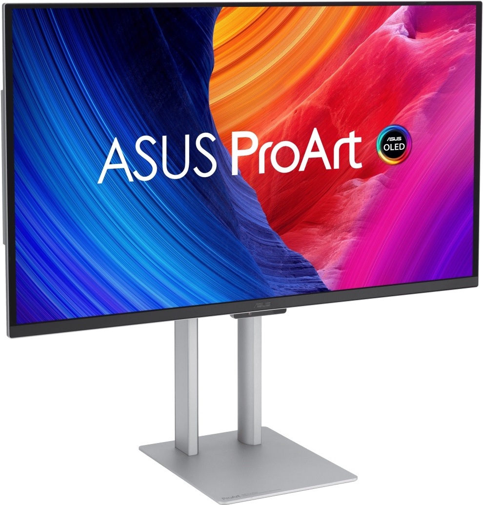 Na obrázku je monitor Asus ProArt OLED PA27UCDMR 27" z předního šikmého pohledu. Má tenký černý rámeček a stříbrný výškově nastavitelný stojan s plochou hranatou základnou. Na obrazovce je výrazná barevná grafika s nápisem ASUS ProArt a logem OLED, kombinující modré, oranžové, červené a fialové odstíny. Monitor působí elegantně a profesionálně, vhodný pro práci s grafikou, fotografiemi a videem.