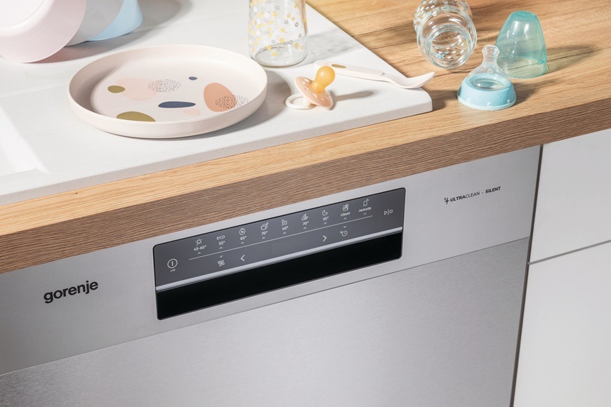 Myčka Gorenje GI643C90X je zabudovaná v moderní domácnosti. Na lince jsou naskládané dětské příbory, lahvičky a dudlík.