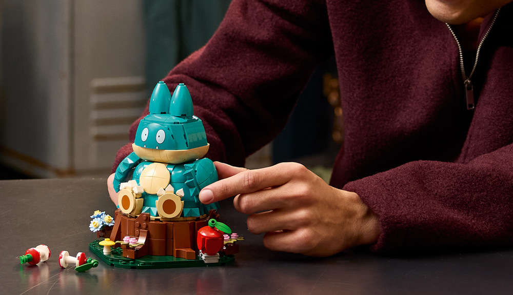 Stavebnice LEGO® Pokémon™ 72150 Pařez, jablko a ohryzky podtrhují Munchlaxovu lásku k jídlu a dodávají výstavní scéně hravý charakter.