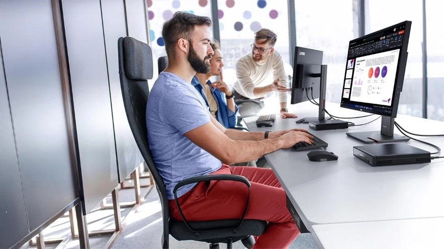 Muž v kanceláře pracuje s počítačem Lenovo ThinkCentre neo 50q Gen 5