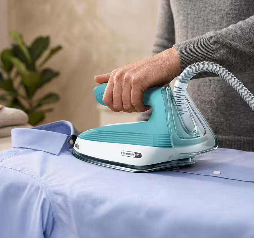 Žehlicí systém Braun Upstyle 2 IS2735.GR zelený Muž žehlí pánskou košili napařovačem Braun IS2735.GR Upstyle 2