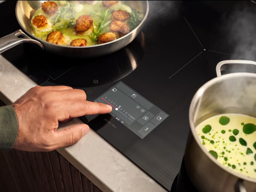 Ruka ovládá displej CookSmart Touch varné desky Electrolux.