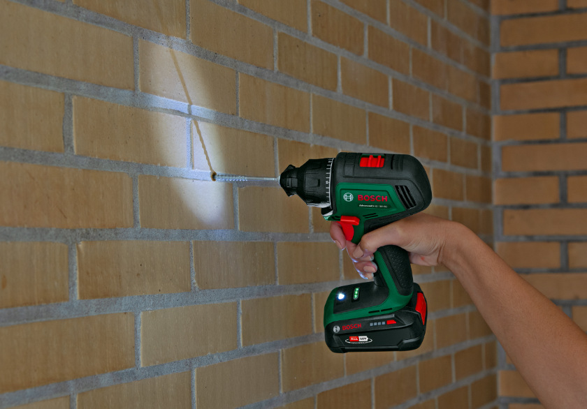 Vrtací šroubovák Bosch AdvancedDrill 18V-80 (bez baterie) Bosch AdvancedDrill 18V-80 s LED osvětlením při vrtání otvoru do cihlové stěny