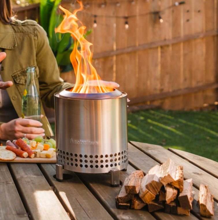 Ohniště Solo Stove Mesa XL Stainless Steel na stole při posezení na zahradě