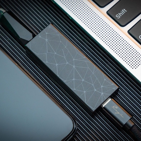Sluchátkový zesilovač Cayin RU3 fialový Detail obrázku zesilovače umístěného vedle notebooku.