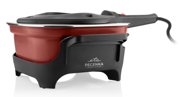 Pohled zboku na Pečenku ETA Ceramic Natura s červenou keramickou nádobou, umístěnou v černém podstavci se zavřeným víkem