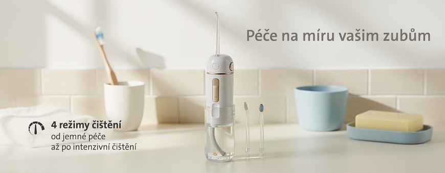Lifestylový obrázek ústní sprchy ETA Aqua Care Compact v koupelně. Text na obrázku: Péče na míru vašim zubům – 4 režimy čištění od jemné péče až po intenzivní čištění. Vedle přístroje jsou zobrazeny dvě výměnné trysky
